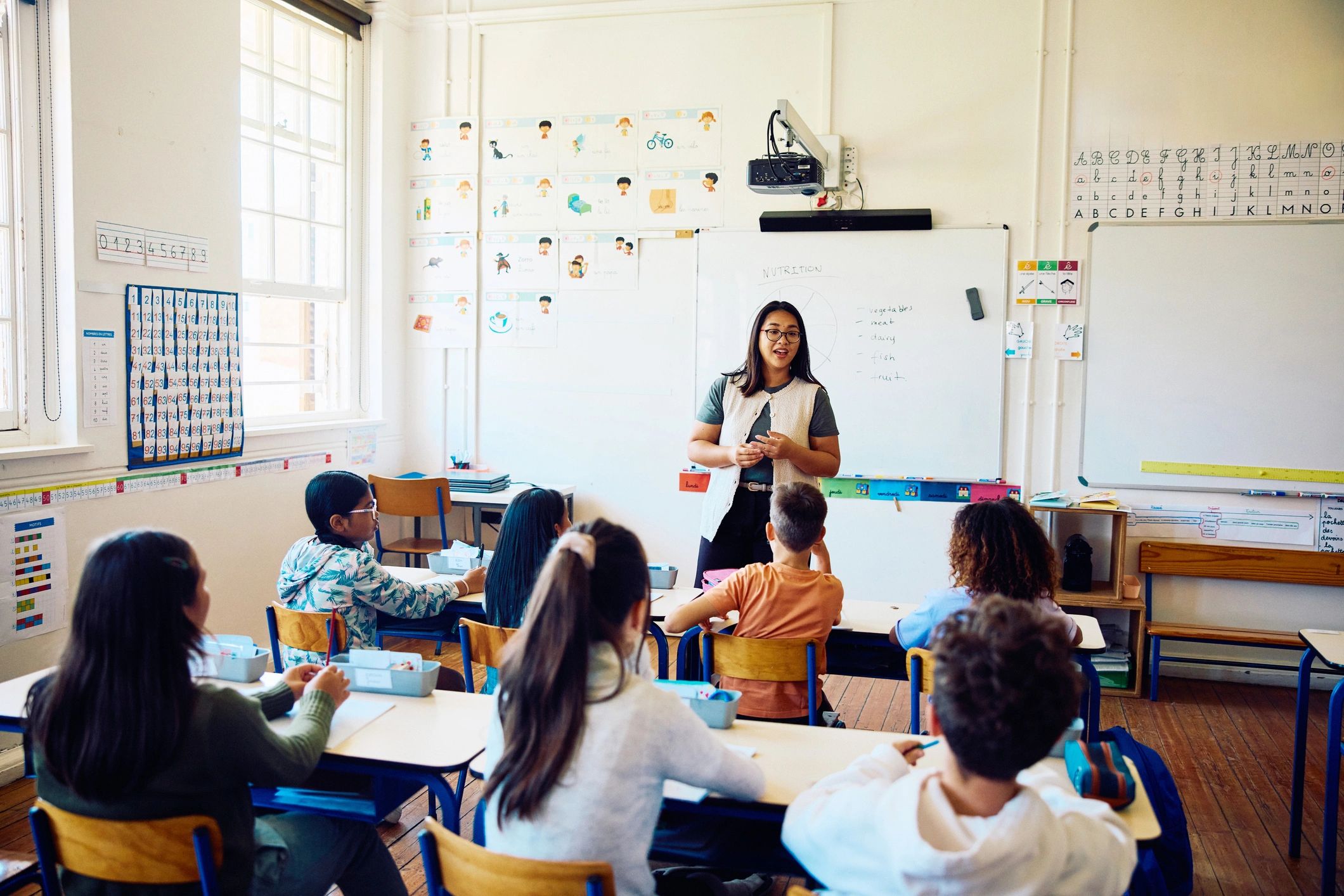 Teacher leading a cheerful classroom lesson with students