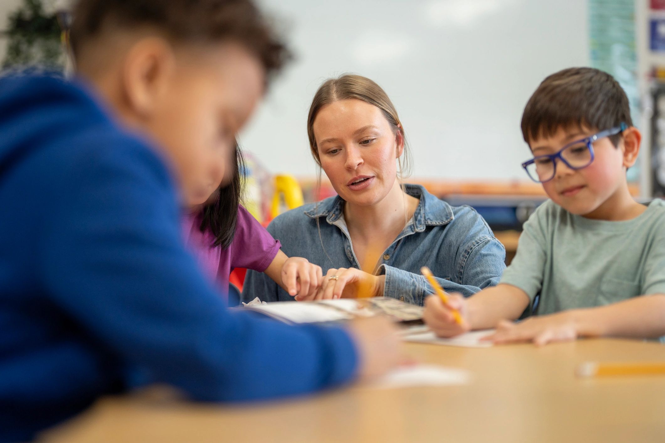 Teacher helping students with a collaborative classroom activity